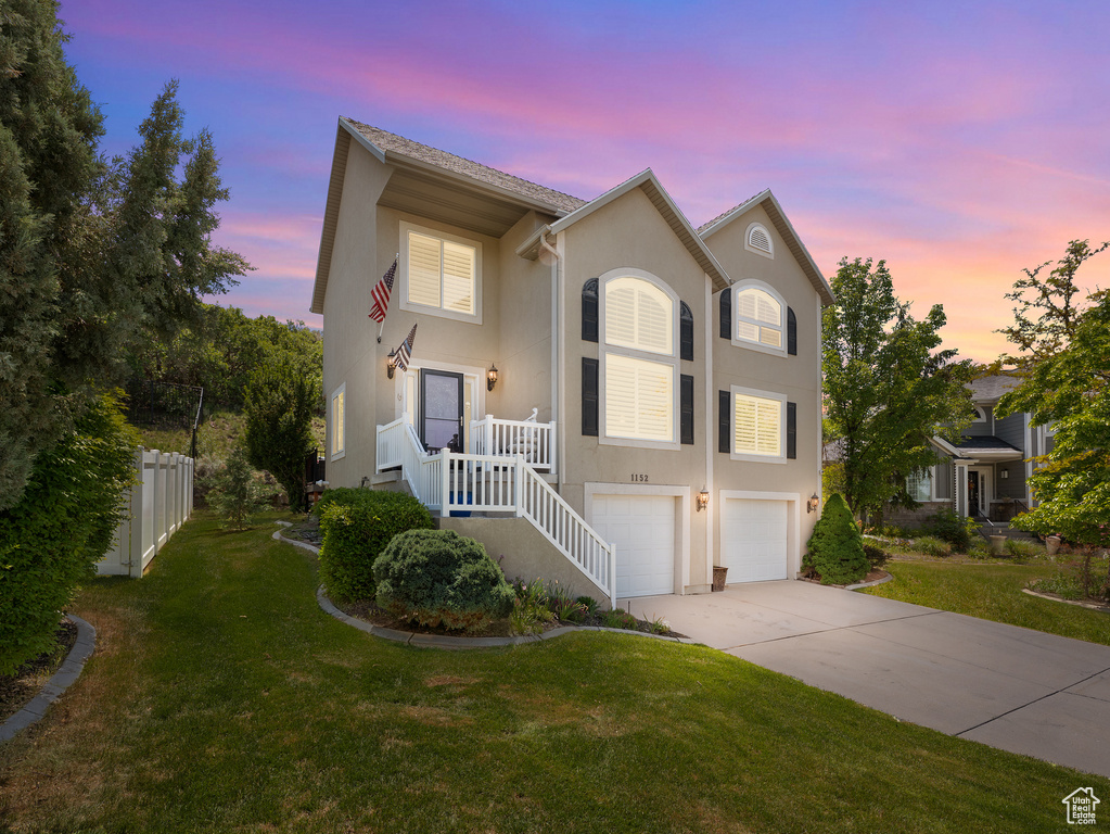 View of front of house with stucco siding, concrete driveway, and a garage