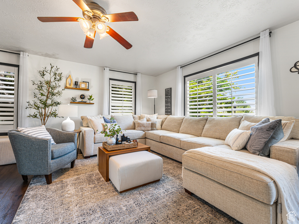 Living area with ceiling fan and wood finished floors