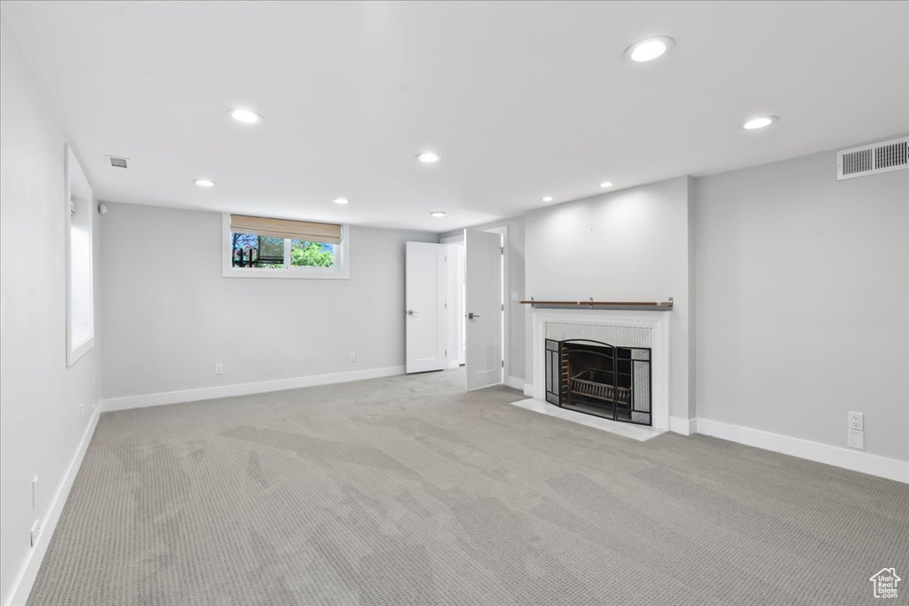 Unfurnished living room with recessed lighting, carpet flooring, baseboards, and a fireplace with flush hearth