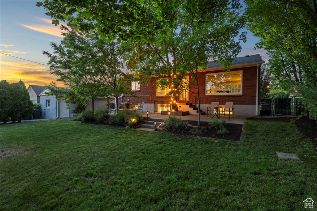 Back of property at dusk with brick siding and a patio area