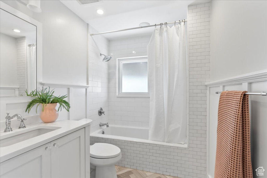 Full bath featuring tiled shower / bath, vanity, and toilet