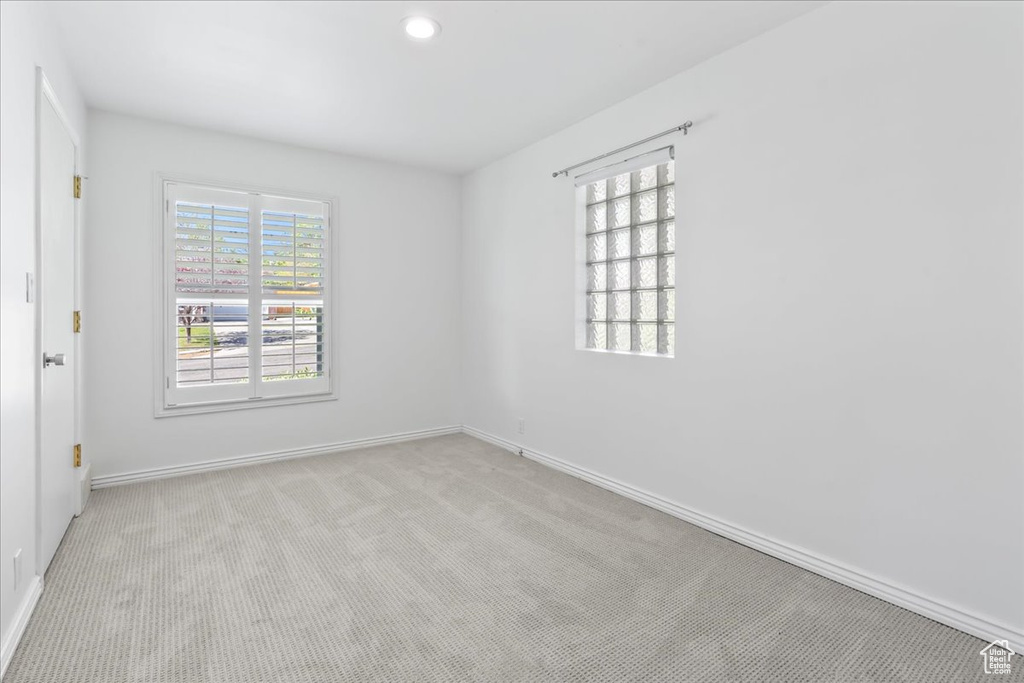 Spare room with baseboards, light carpet, and recessed lighting