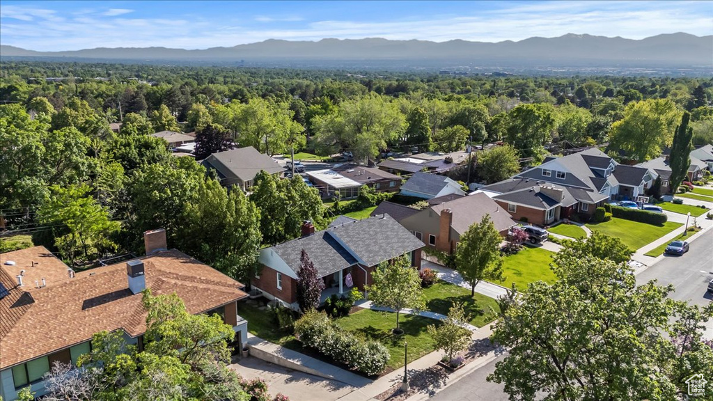 Aerial perspective of suburban area with mountains and a heavily wooded area