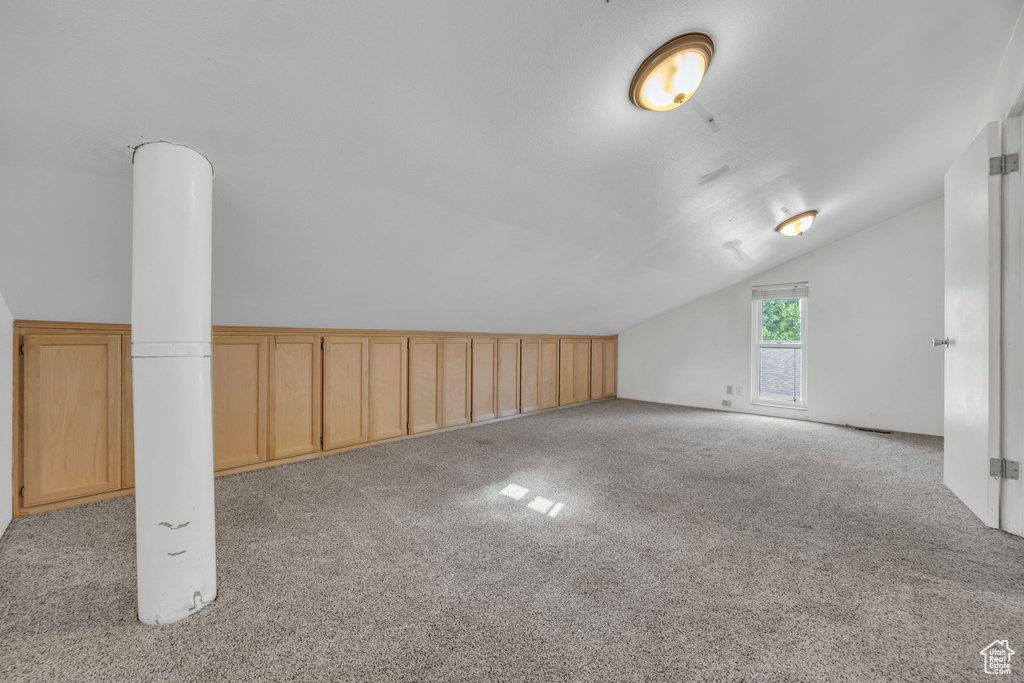 Bonus room featuring lofted ceiling and light colored carpet