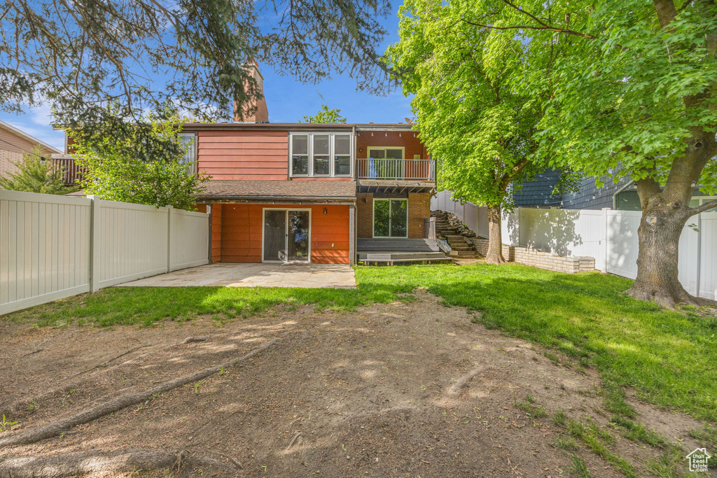 Rear view of property featuring a patio, stairway, and a chimney