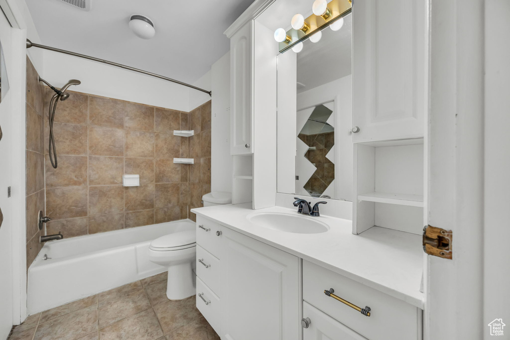 Bathroom with vanity, toilet, shower / tub combination, and tile patterned flooring