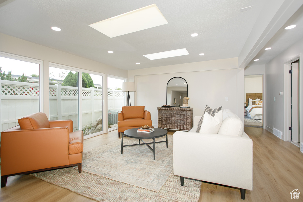 Living area featuring light wood-style floors, recessed lighting, and a skylight