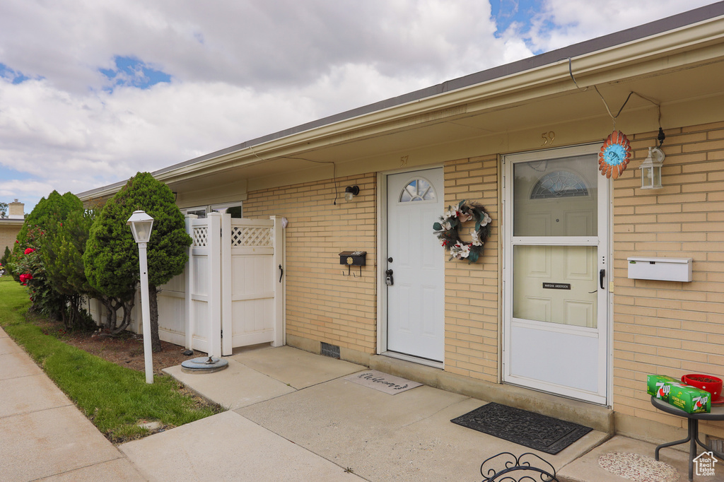 Doorway to property featuring brick siding