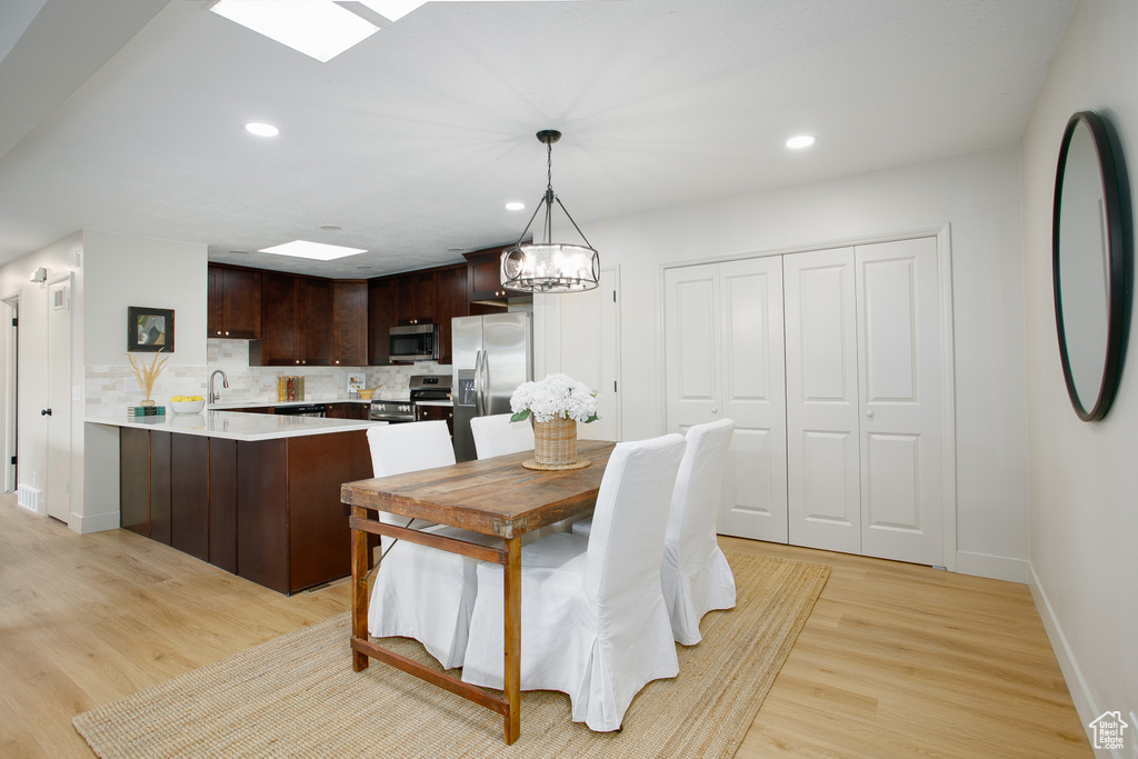 Dining area with light wood-type flooring, baseboards, and recessed lighting