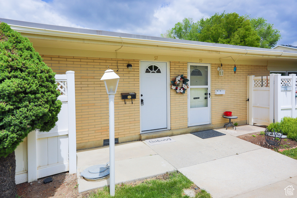 Doorway to property featuring brick siding