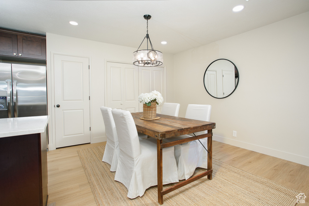 Dining room featuring a chandelier, light wood-style flooring, baseboards, and recessed lighting