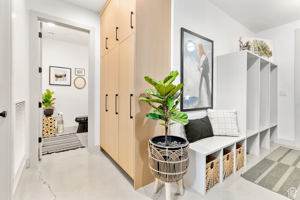 Mudroom featuring finished concrete floors and baseboards