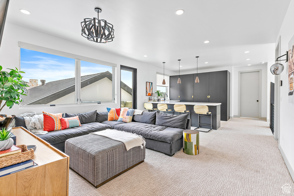 Living area with recessed lighting, light carpet, and a chandelier
