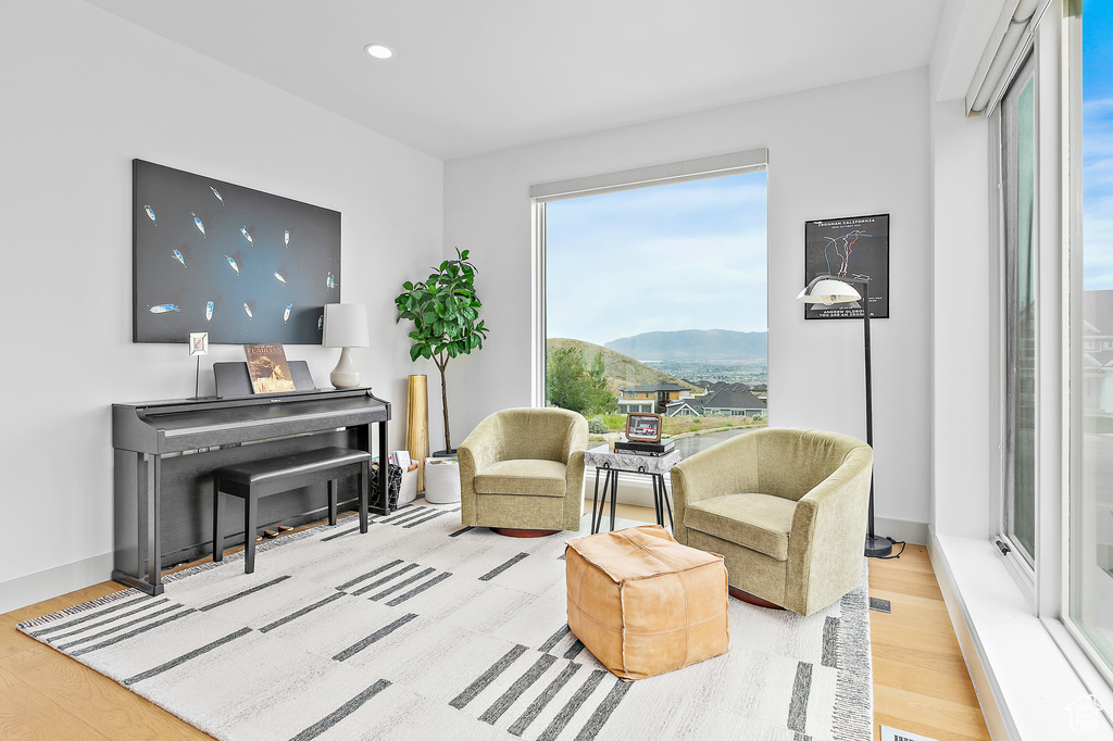 Sitting room with wood finished floors, a mountain view, and recessed lighting