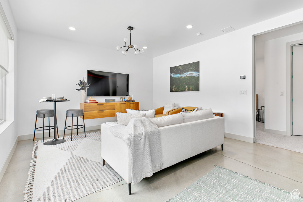 Living room featuring a chandelier, recessed lighting, and baseboards