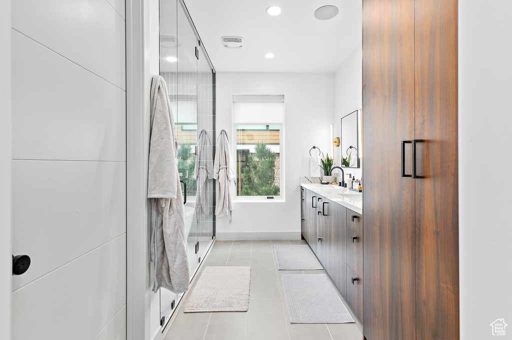 Bathroom featuring vanity, a stall shower, tile patterned flooring, recessed lighting, and baseboards