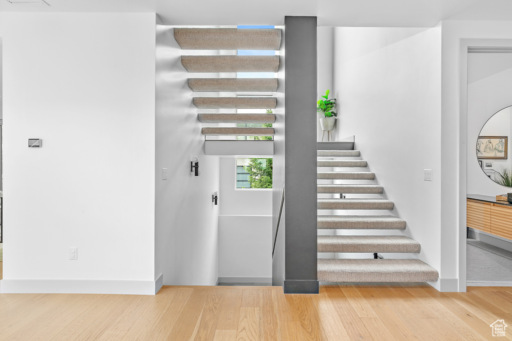 Stairs featuring wood finished floors and baseboards