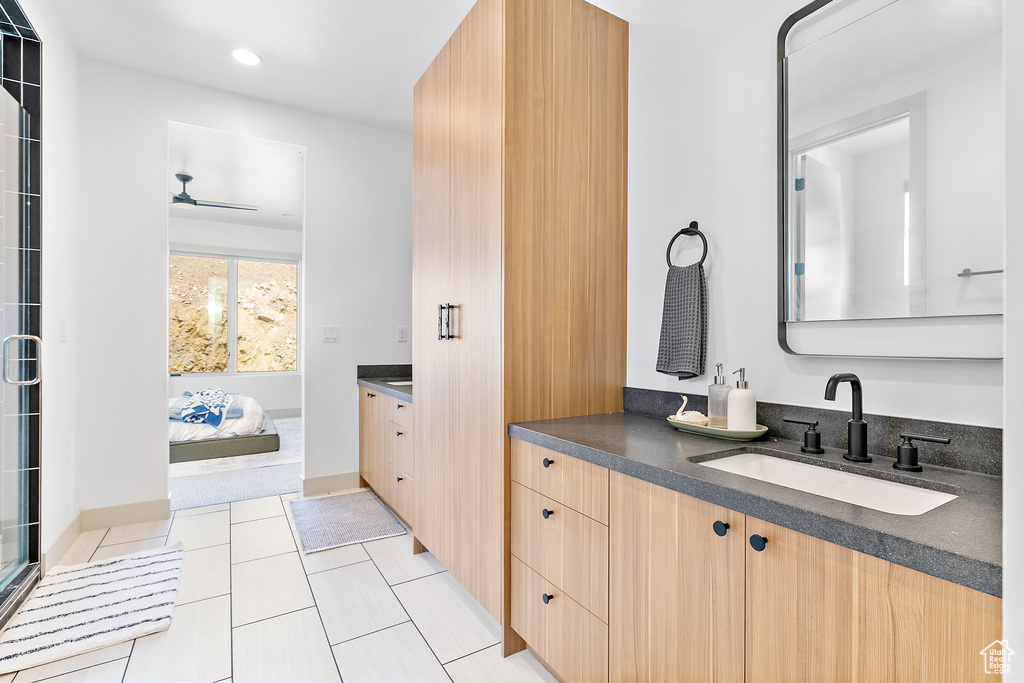 Ensuite bathroom featuring vanity, a ceiling fan, recessed lighting, a shower with shower door, and tile patterned floors