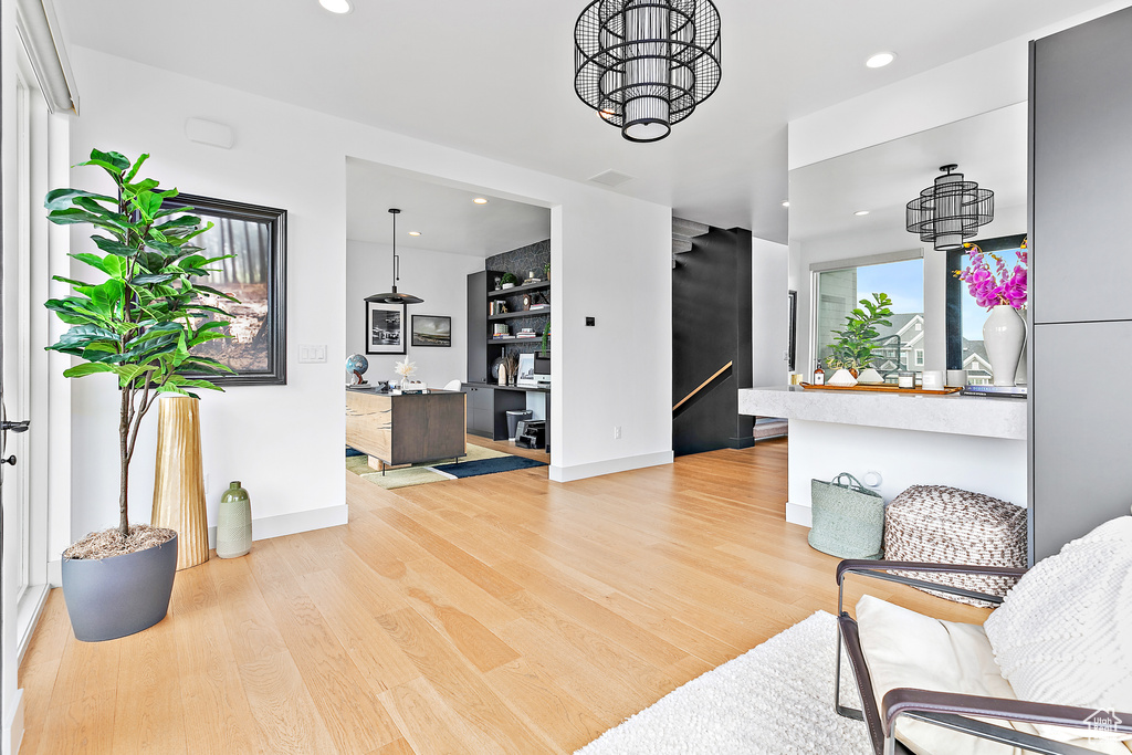 Living area with light wood-style floors, recessed lighting, baseboards, and a chandelier