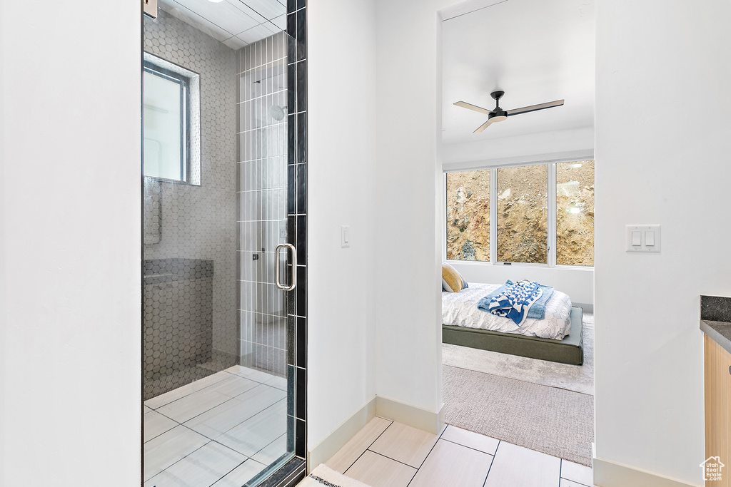 Bathroom with a stall shower, tile patterned flooring, ceiling fan, baseboards, and connected bathroom