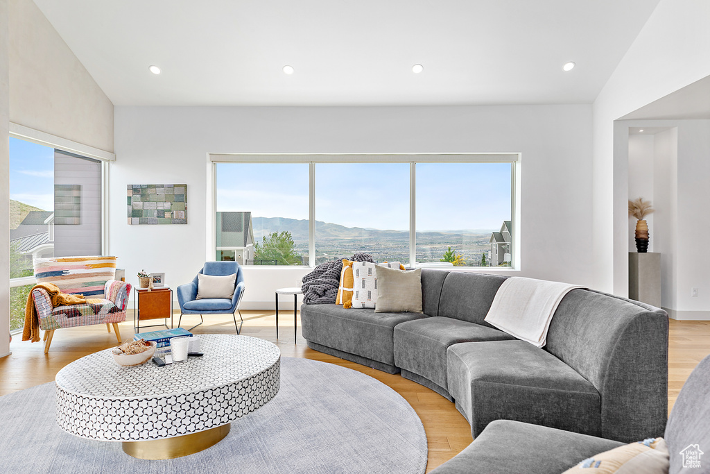 Living room with a mountain view, light wood-style flooring, and recessed lighting