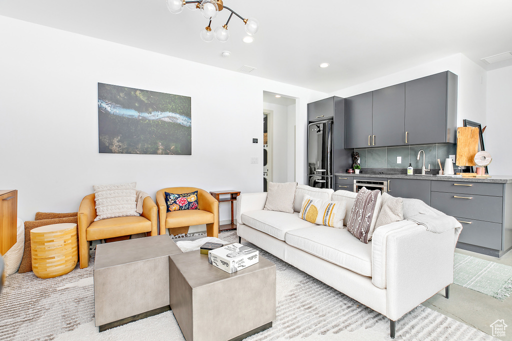 Living area with bar with sink, a chandelier, and recessed lighting