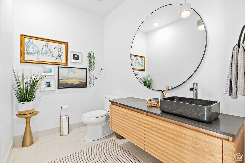 Bathroom featuring toilet, vanity, and tile patterned floors