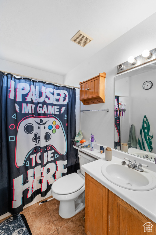 Bathroom featuring toilet, vanity, tile patterned flooring, and a shower with shower curtain