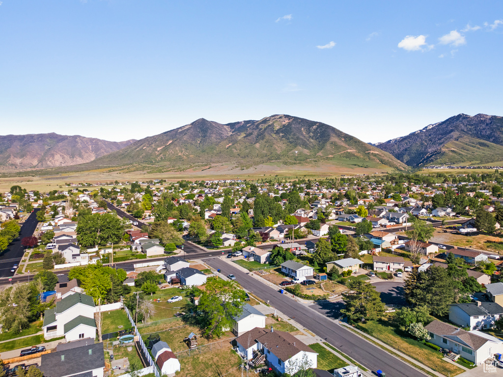 Aerial view of property and surrounding area with nearby suburban area and mountains