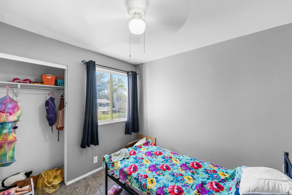 Bedroom featuring carpet flooring, baseboards, ceiling fan, and a closet