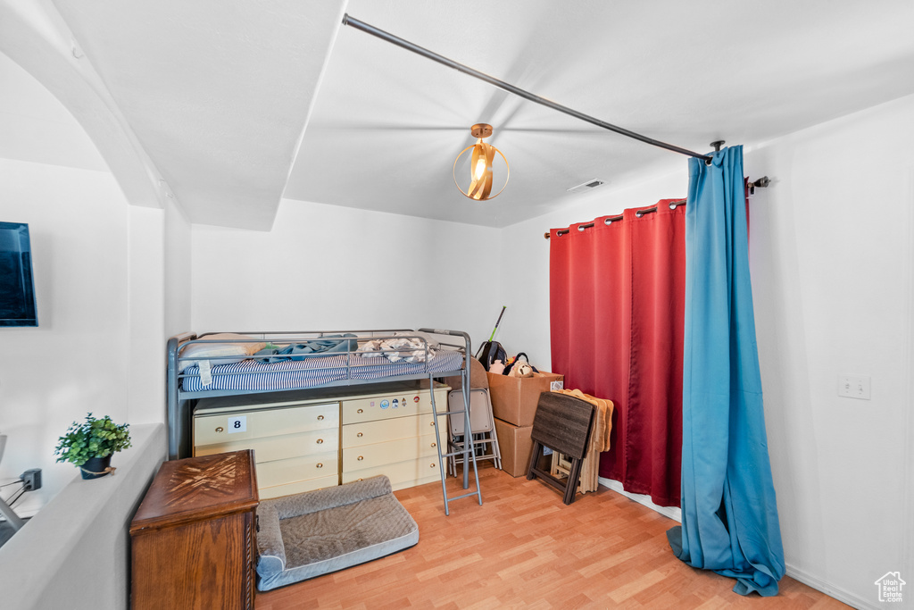 Bedroom featuring wood finished floors and arched walkways