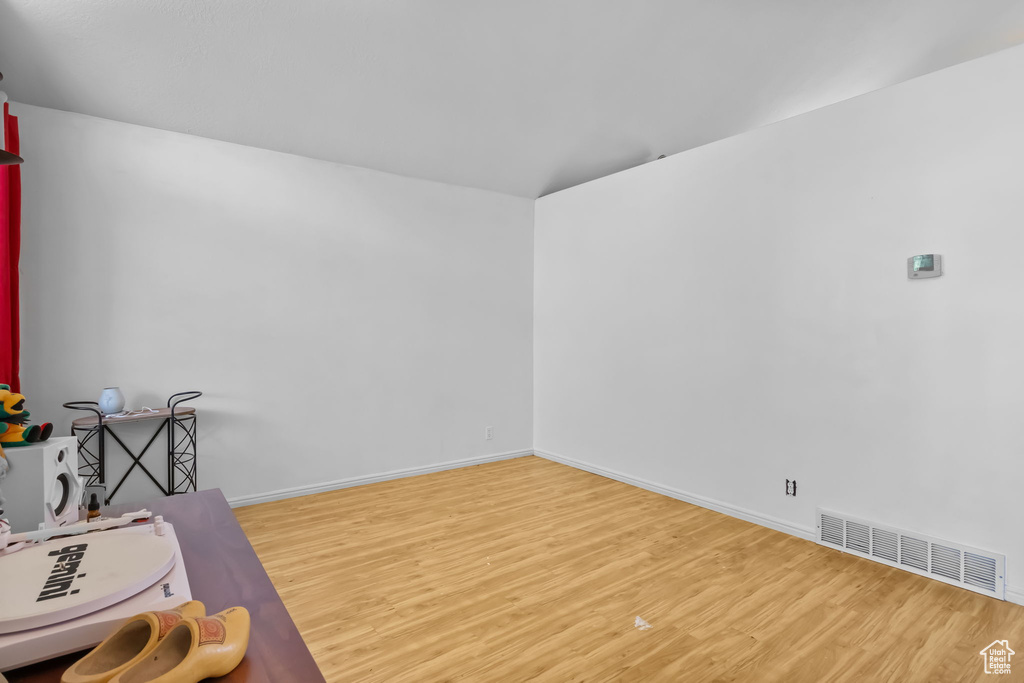 Unfurnished room with wood finished floors and baseboards