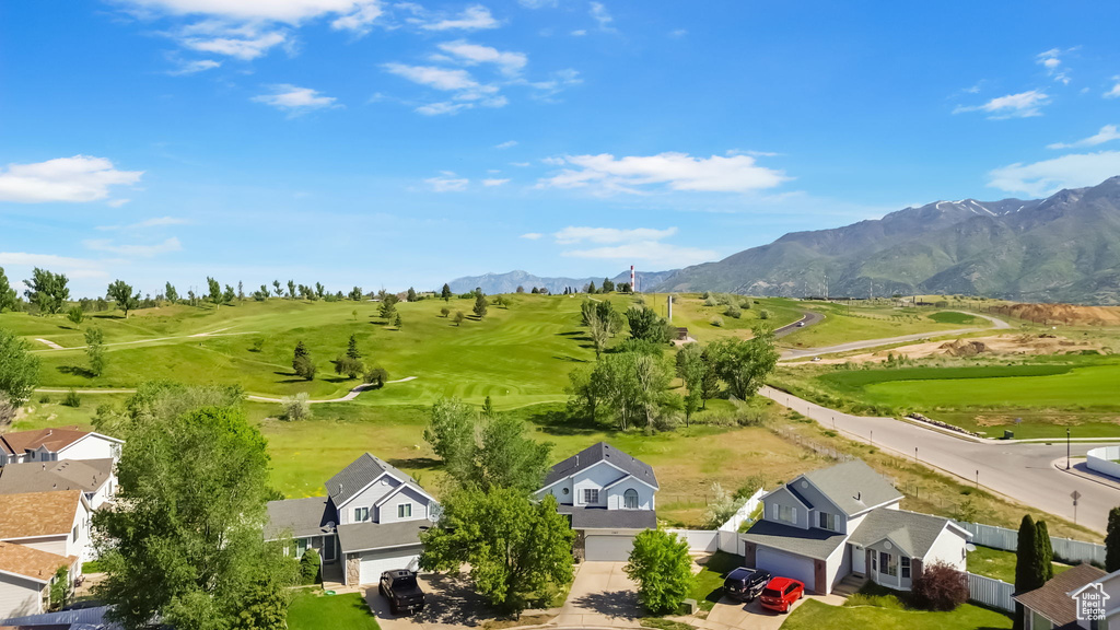 Aerial perspective of suburban area featuring a mountainous background and a golf club
