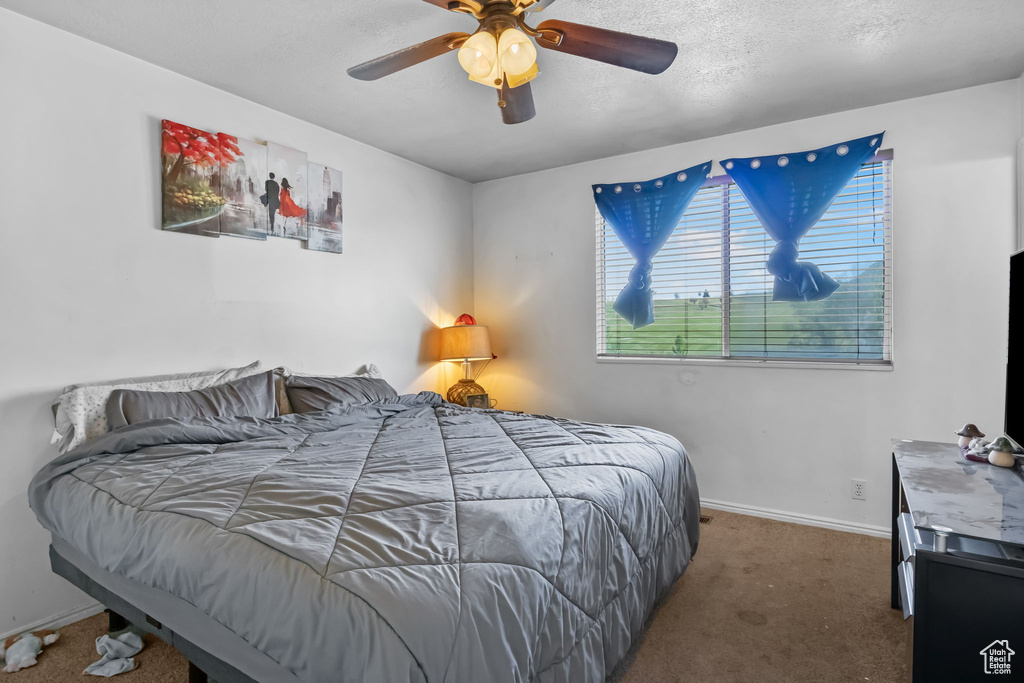 Carpeted bedroom featuring baseboards and a ceiling fan