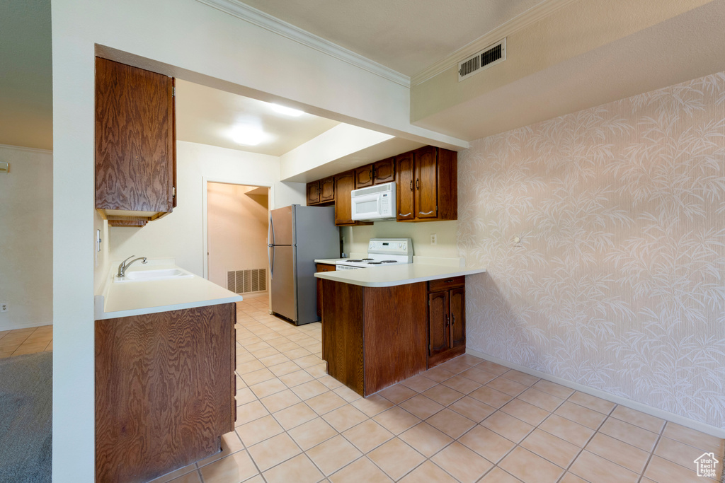 Kitchen featuring white microwave, freestanding refrigerator, wallpapered walls, electric range, and a peninsula