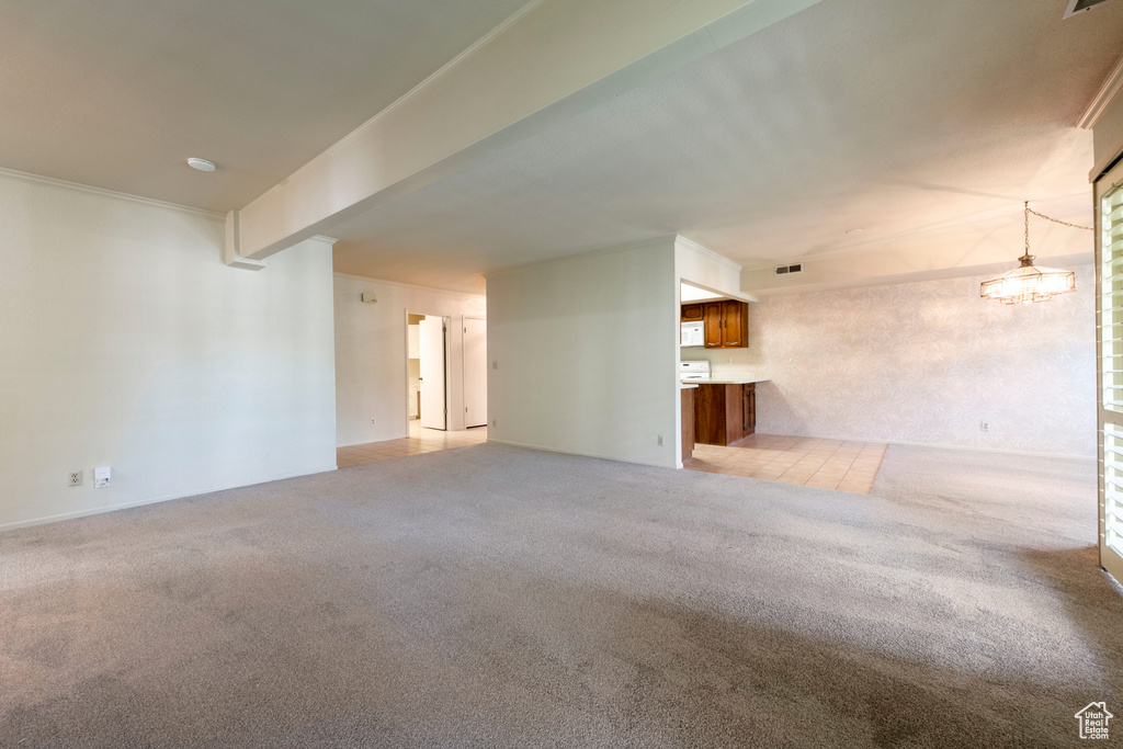 Unfurnished living room with light carpet and a chandelier