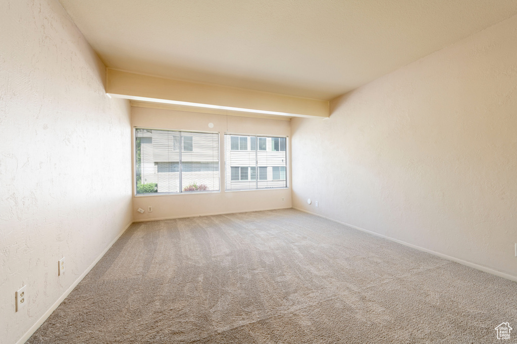 Empty room with carpet floors and baseboards