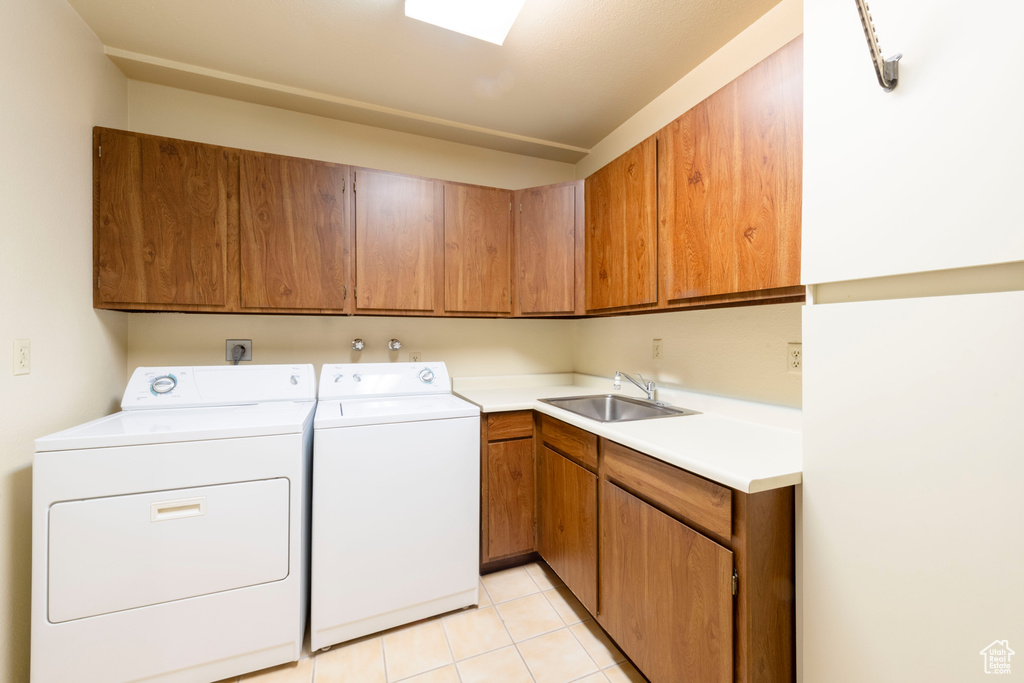 Laundry area featuring cabinet space, independent washer and dryer, and light tile patterned floors