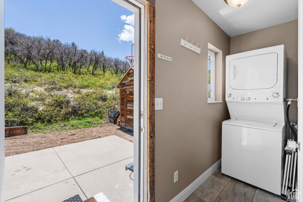 Laundry room featuring estacked washer and dryer and baseboards