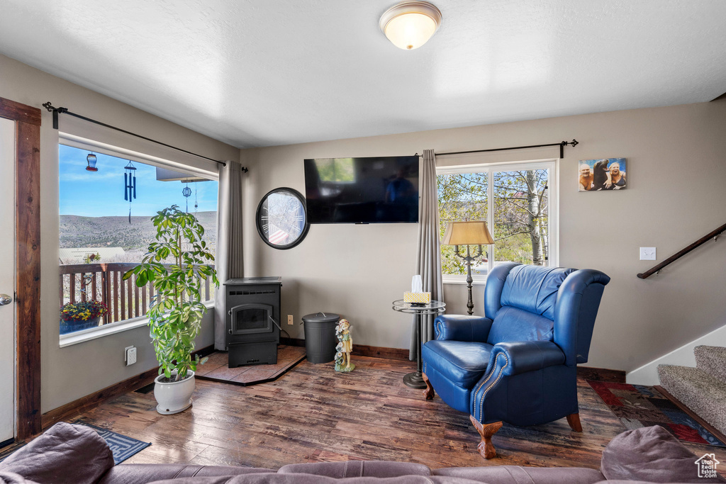 Living room with stairs, wood finished floors, plenty of natural light, and baseboards