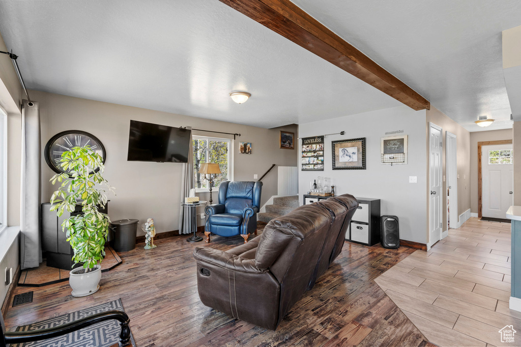Living area featuring wood finished floors, healthy amount of natural light, and baseboards