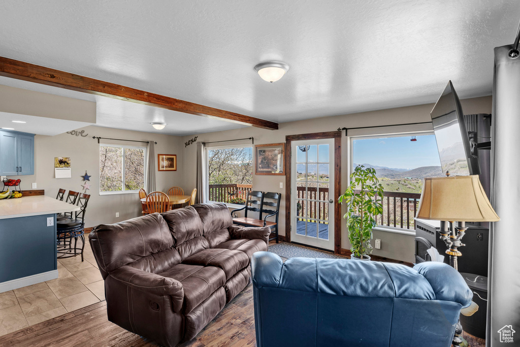 Living area featuring beam ceiling and light wood-style floors