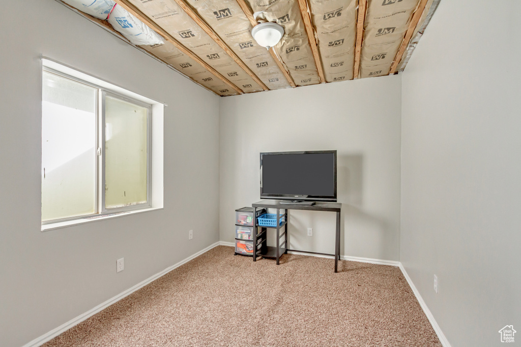 Carpeted home office featuring baseboards
