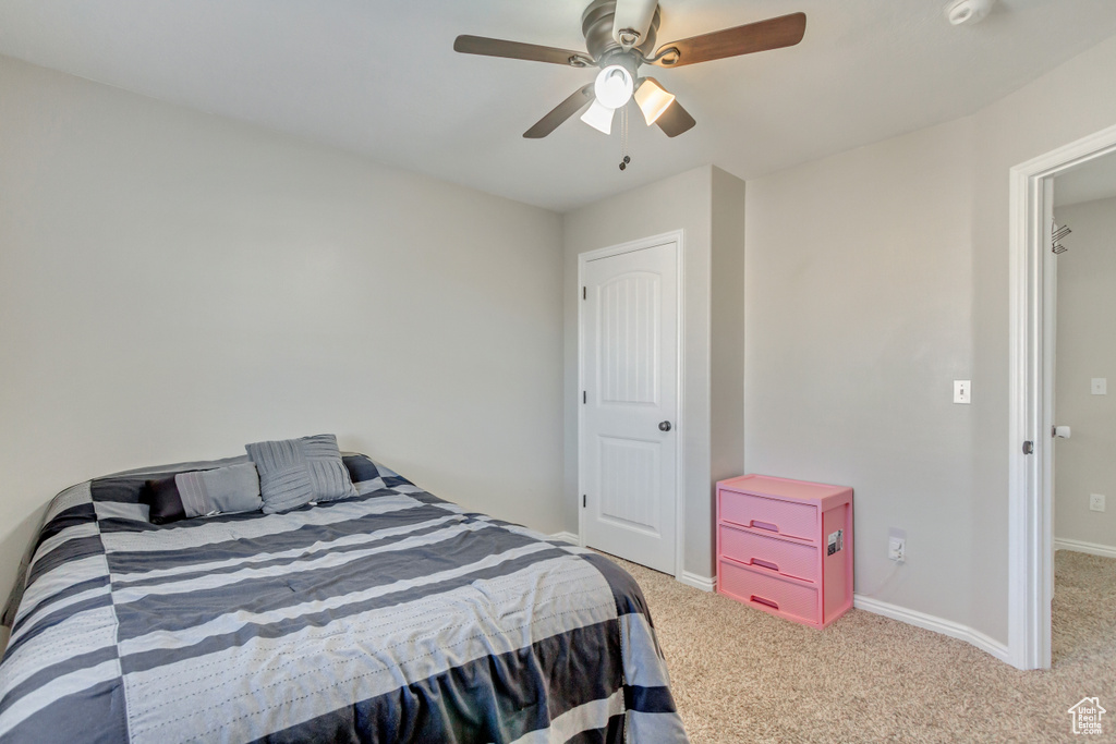 Carpeted bedroom with baseboards and a ceiling fan