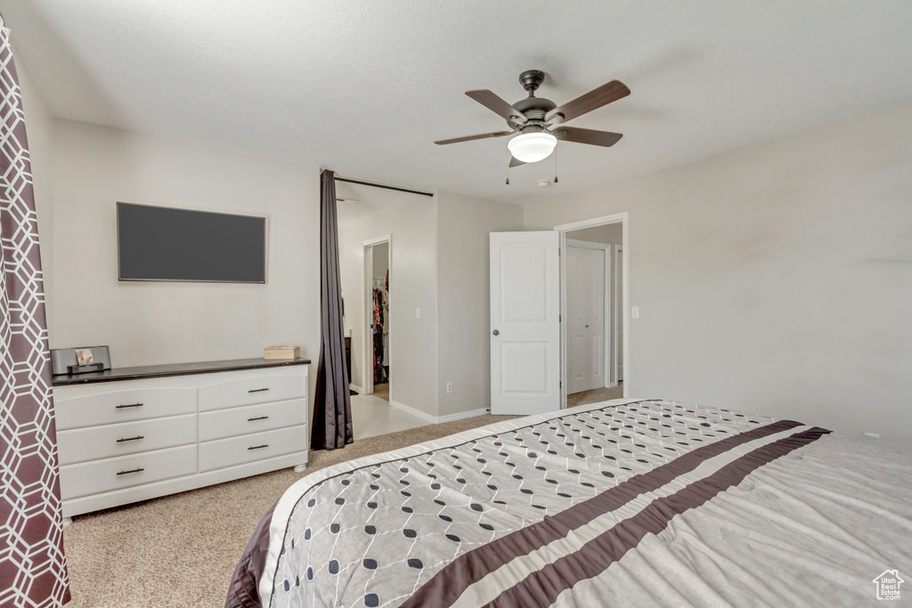 Bedroom with light carpet and a ceiling fan