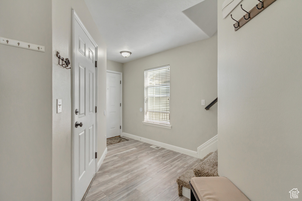 Foyer entrance with light wood-style flooring and baseboards