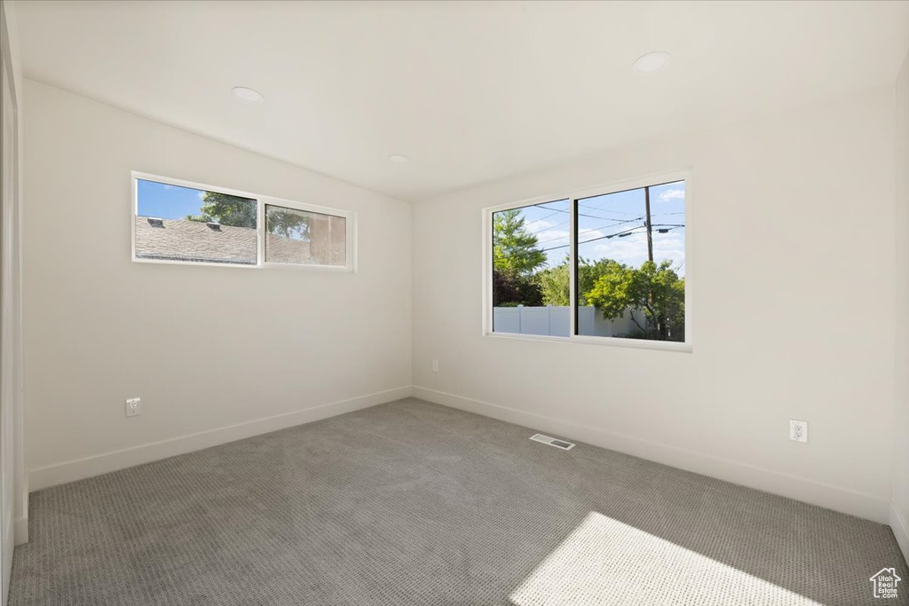 Spare room with plenty of natural light, carpet flooring, baseboards, and recessed lighting