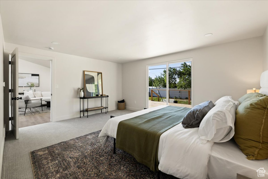 Bedroom with access to exterior, carpet flooring, and baseboards