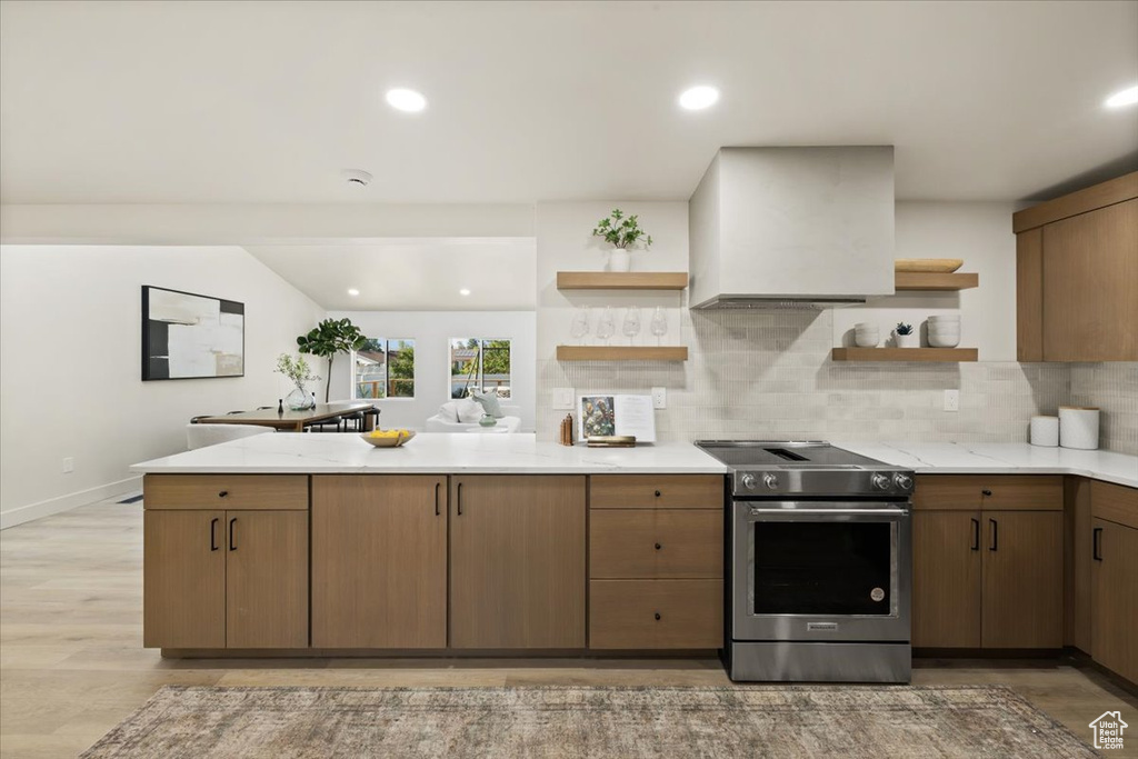 Kitchen with open shelves, stainless steel electric range oven, a peninsula, backsplash, and light wood-style floors