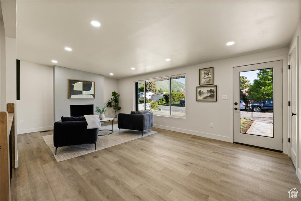 Living room featuring plenty of natural light, light wood-style flooring, recessed lighting, and baseboards